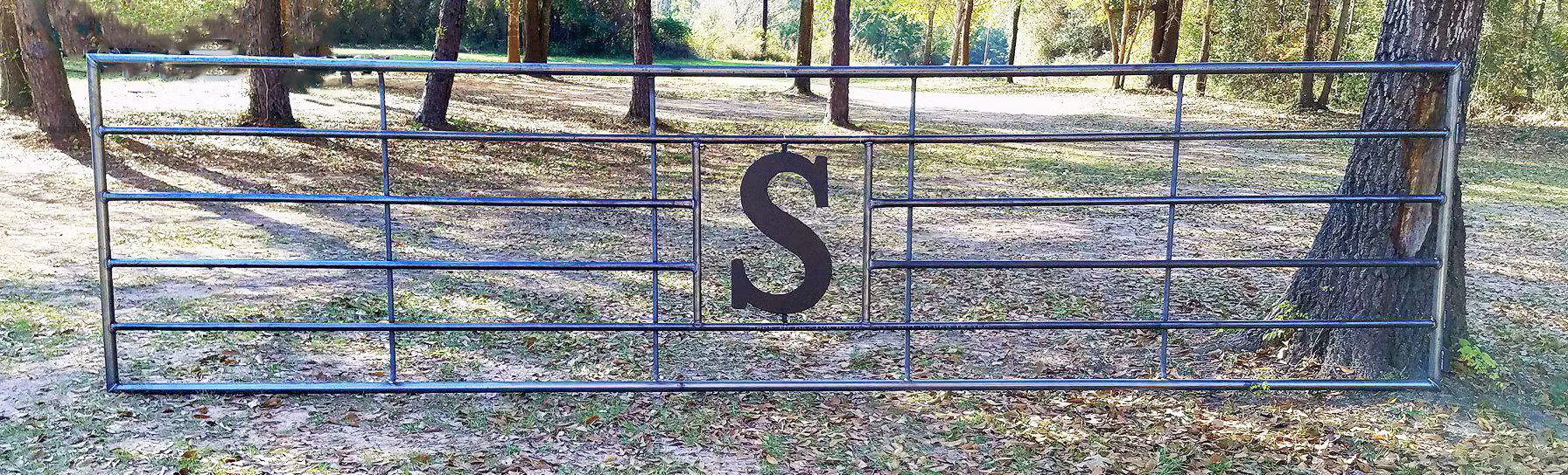 "Custom gate designed for livestock fencing, showcasing elegant craftsmanship ideal for cattle pens, featuring durable continuous fence panels and a tough bar fence structure."