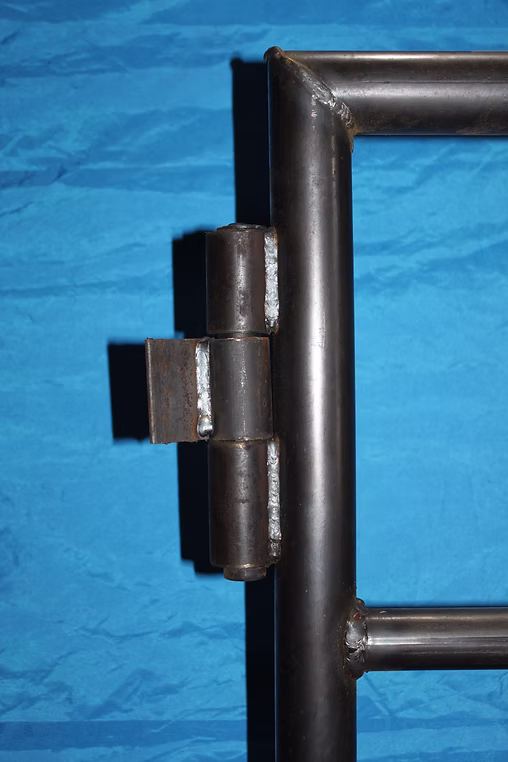 "Close-up of gate hinges weld used in livestock fencing, showcasing durable construction for cattle pens and continuous fence panels, ideal for tough bar fence applications."